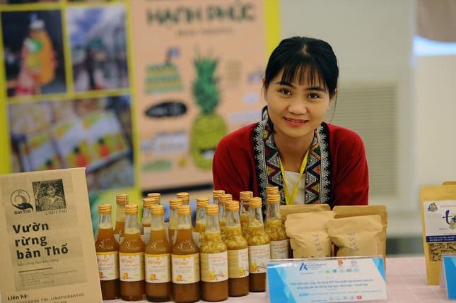 Chị Nguyễn Lê Ngọc Linh (người Thổ, sinh năm 1990) ở thôn Thanh Xuân, xã Hóa Quỳ, huyện miền núi Như Xuân, tỉnh Thanh Hóa và sản phẩm mật ong sạch của Vườn rừng bản Thổ. Ảnh: Nguyễn Nam - TTXVN